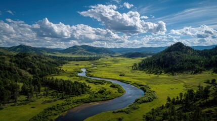 Fototapeta premium Scenic aerial view of a winding river flowing through a lush green mountain valley under a blue cloudy sky
