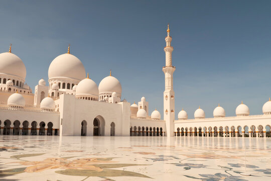 View over the inner courtyard with one of the main buildings, a minaret and cloisters, colonnades, arcades in the background, Sheikh Zayed Grand Mosque, Abu Dhabi, UAE, United Arab Emirates