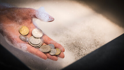 Human Hand Holding Loose Coins Over Foamy Sink &mdash; Conceptual Financial Crime