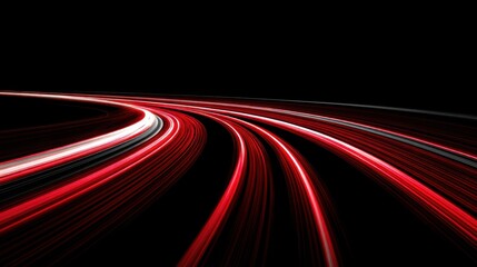 Bright light trails from vehicles move along a curved road at night. The scene displays the contrast of lights against a dark background showing the motion of traffic.