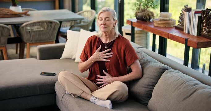 Breathing, meditation and senior woman on sofa in home with calm, relax or peaceful balance. Yoga, spiritual and elderly female person with grounding ritual in morning in living room at house.