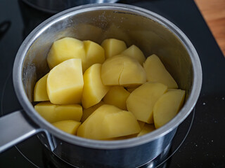 Boiled potatoes in pot on electric stove, close-up