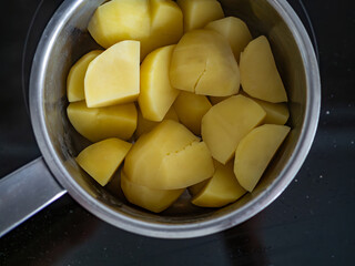 Boiled potatoes in pot on electric stove, close-up. Top view