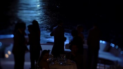 Elegant evening gathering on a luxury yacht with guests enjoying drinks and conversation. A celebration of sophistication and leisure on the water