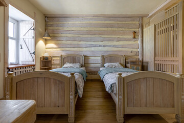 Symmetrical rustic bedroom with wooden twin beds and timber wall