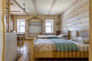 Rustic studio apartment interior with twin beds and wooden decor