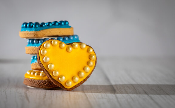 Valentine&rsquo;s day composition with cookies in shape of hearts decorated by yellow and blue icing and sprinkles on towel embroidered with Ukrainian ornament