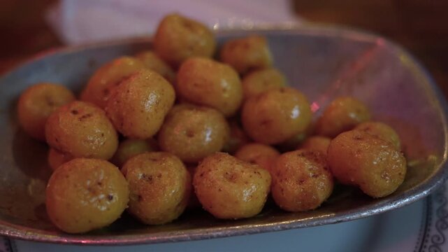 A detailed view of golden papas criollas seasoned perfectly, served in a rustic dish under warm, inviting lighting, capturing the essence of Colombian culinary delights.