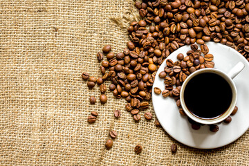 coffee beans, coffe cup on linen cloth background top view