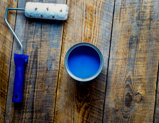 painting with can of blue paint and roller top view