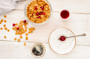 flakes in bowl with berries on wooden background top view