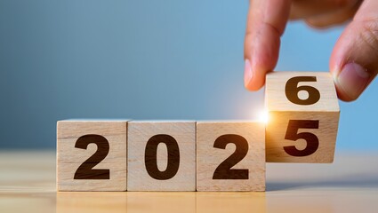 Hand Changing Year From 2025 to 2026 on Wooden Blocks Display