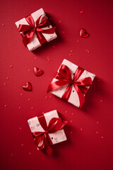 Flat lay of scattered Valentine's presents on a red background.