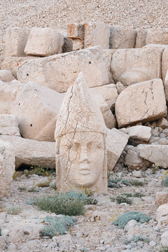 giant stone head statue of apollo mithras at mount nemrut archaeological site in adiyaman turkey with scattered ruins and dry plants