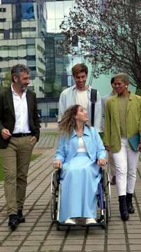 Diverse business team with a colleague in a wheelchair walking together