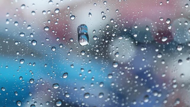 Raindrops on a car windshield during rainy weather, viewed from inside the vehicle, creating a calm and relaxing atmosphere
