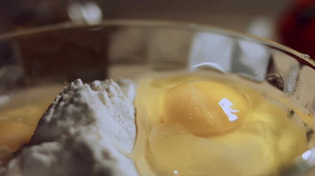 Chicken eggs and a pile of white flour in a bowl. close up view