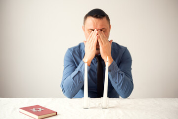 Jewish man praying with Shabbat candles. Shabbat Shalom.