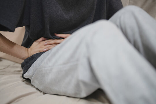 Flatulence ulcer, asian young woman, girl hands in belly, stomachache from food poisoning, abdominal pain and digestive problem, gastritis or diarrhoea. Abdomen inflammation, menstrual period people.