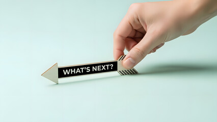 Hand Holding Wooden Arrow Sign with 'What's Next?' Text, Symbolizing Future Decisions and Forward Thinking
