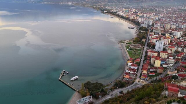 Aerial twilight video of Pogradec, Albania, with the city curving along Lake Ohrid under soft evening reflections.