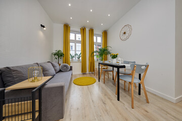 Salon w nowoczesnym apartamencie z szarą sofą i musztardowymi zasłonami © arteffect.pl