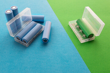 A stack of cylindrical 18650 batteries on a blue-green background, rechargeable lithium-ion batteries for electrical appliances and devices. Battery cell or secondary element.