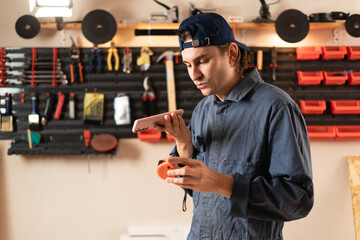 male mechanic or repairman holding yellow measuring tape using mobile app dictate voice message...