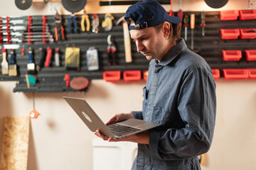 carpenter with laptop. Joinery, woodwork, app for project at workshop