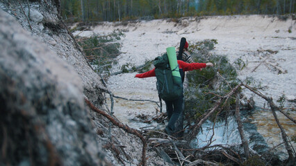 A young woman and woman crossing the river on the log