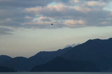 夕焼け空を飛ぶヘリ