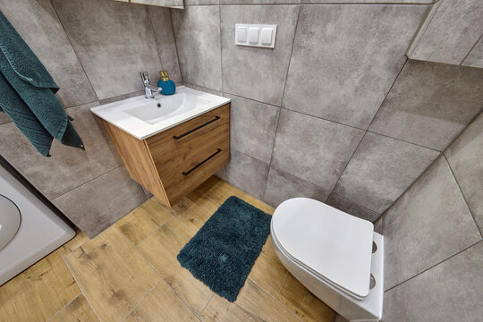 Łazienka w kawalerce z kabiną prysznicową w stonowanych kolorach