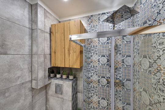 Łazienka w kawalerce z kabiną prysznicową w stonowanych kolorach