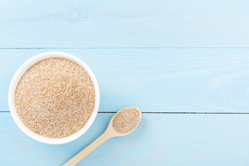Psyllium husk powder with fresh leaves on wooden background, top view © Liami