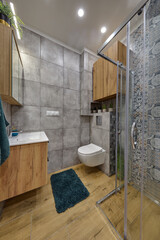 Łazienka w kawalerce z kabiną prysznicową w stonowanych kolorach