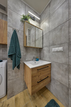 Łazienka w kawalerce z kabiną prysznicową w stonowanych kolorach