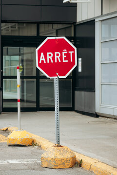 French Stop Sign &ldquo;Arret&rdquo; at Modern Building Entrance in Quebec, Canada