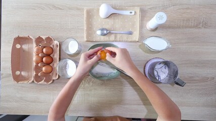 Top-down view of hands cracking an egg into a bowl of flour mixture, then whisking it smooth. Perfect for baking tutorials clean, simple, and focused on foundational techniques.