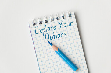 Explore Your Options text, Time concept. On a white surface, a notebook and blue pencil