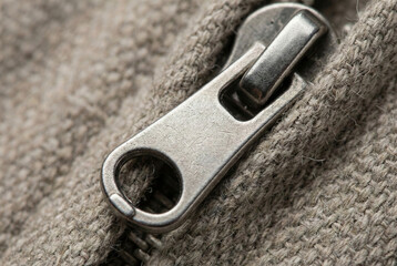 Close-up of mClose-up of metal zipper pull on knitted fabricetal zipper pull on knitted fabric