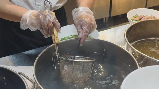 Chef Prep Pho in restaurant kitchen looks very professional. Detail of Chef Prep Pho shows boiling beef for broth. Every Chef Prep Pho makes asian noodle soup tasty for all hungry customers.