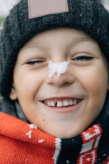 a boy in a New Year's scarf with a snowflake on his nose