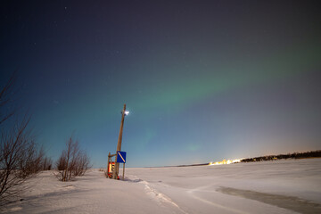 Frozen shipping lane near the artic circle, Oulu Finland. The Northern Lights are visible in the sky.