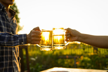 A close-up image of two beer glasses in hands, with the sound of the glasses clinking together in the backyard.