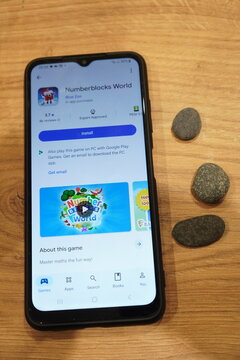 Numberblocks World app displayed on a smartphone screen with pebbles nearby