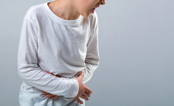 Child has stomachache with food poisoning. Stomach pain. Teen boy with stomachache. Child having terrible pain in stomach. Diarrhea or gastroenteritis health problem. Copy space