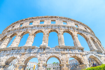 This stunning Roman amphitheatre in Pula stands majestically under a clear blue sky, showcasing its...