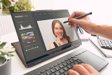 Photo retoucher working on 2-in-1 laptop