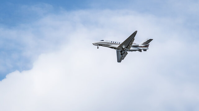 Private Jet Flying Through Cloudy Sky