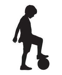 Silhouette of a young boy playing soccer, with his foot on the ball, ready to kick.